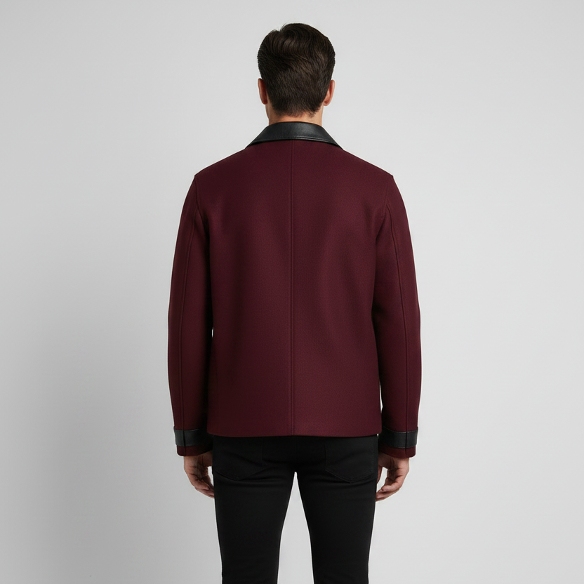 A man viewed from the back wearing a burgundy blazer with black leather trim on the collar, cuffs, and hem, 